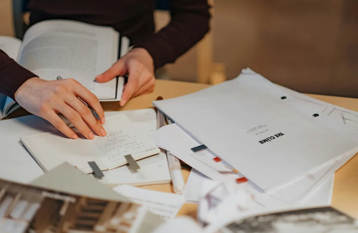A writer's desk with papers and a notebook in warm light